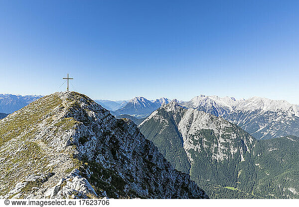 Clear sky over summit cross of Brunnensteinspitze mountain