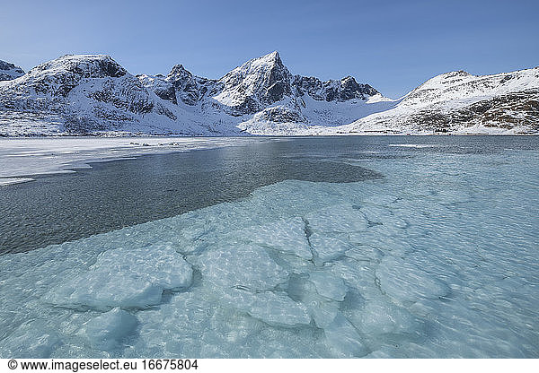 Clear water covers icy bay at Flakstadpollen  Flakstadøy  Lofoten Islands  Norway