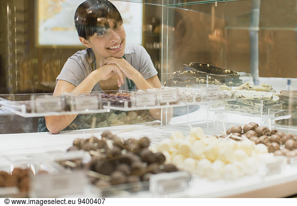 Clerk smiling behind candy counter in store
