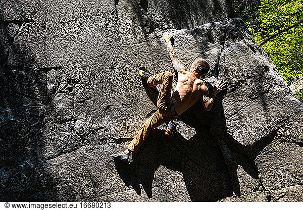 Climber using heel hook to get to the top of the boulder
