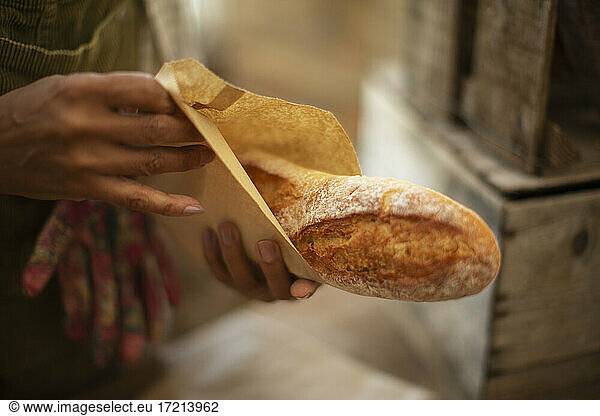Close up Bäckerin hält frisch gebackenes Baguette-Brot