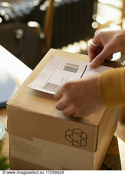 Close up business owner placing shipping label on box