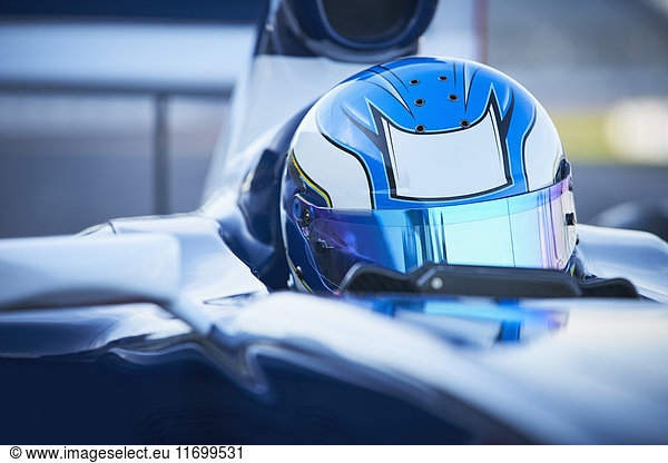 Close up formula one race car driver wearing blue helmet