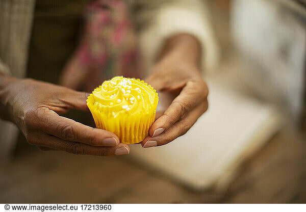 Close up Frau hält leuchtend gelbe Zitrone Cupcake