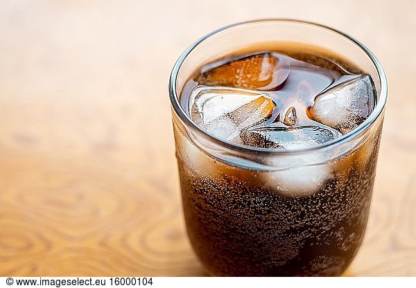 Close up Glass filled with carbonated cola soft drink with ice cubes. selective focus.