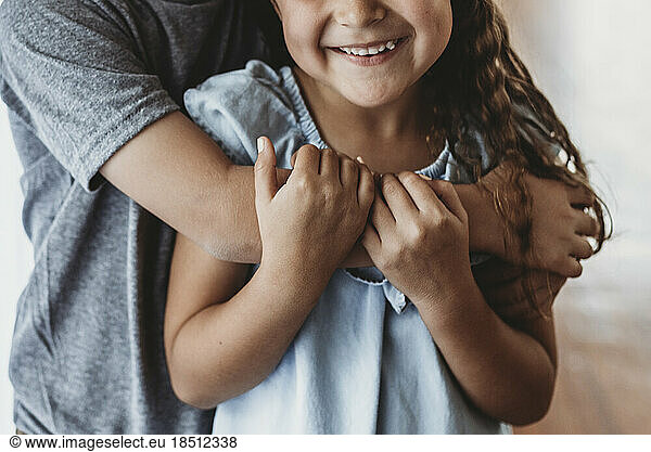Close up image of brother embracing sister and sister smiling