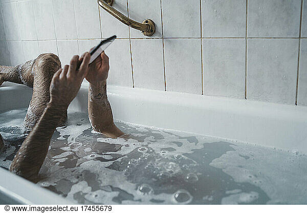 close up man holding the phone with his head underwater