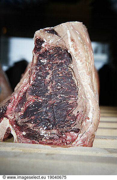Close up of a beef steak aging on a drying rack.