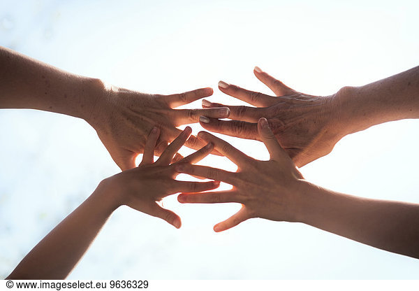 Close up of a family hands together against sunlight