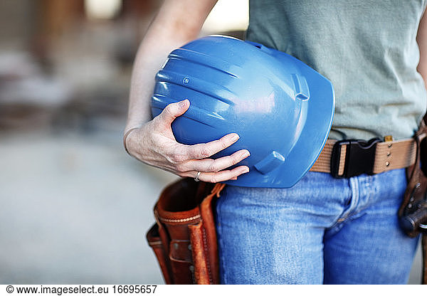 Close up of a female construction worker holding a hard hat