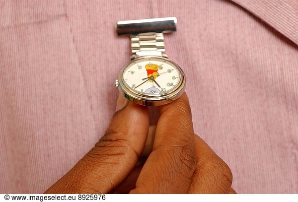 Close up of a female nurse holding her fob watch.