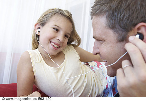 Close-up of a girl listening to music with her father. Close-up of a girl listening to music with her father