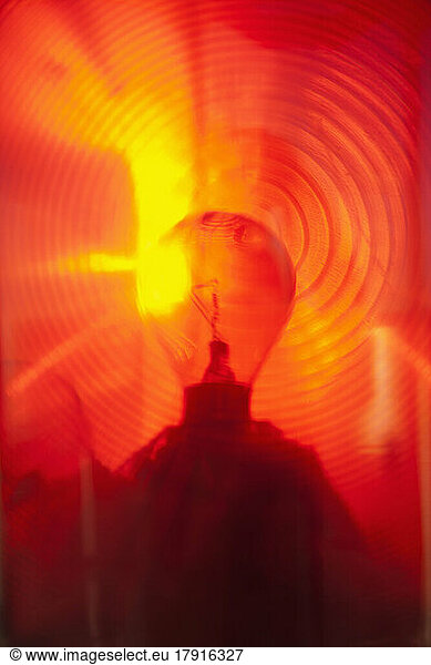 Close up of a lantern and lightbulb  radiating heat and light  red and yellow.