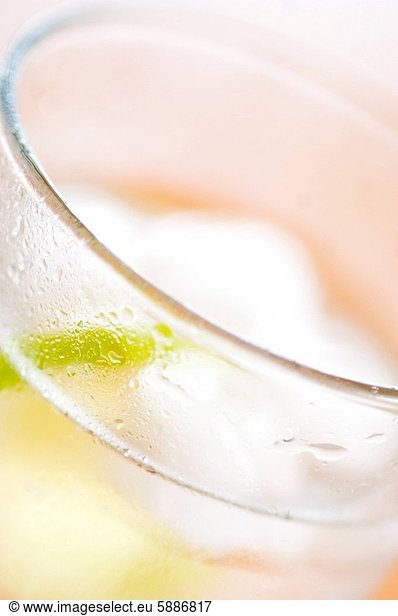 Close_up of a lemon slice inside a glass of purified water with ice cubes