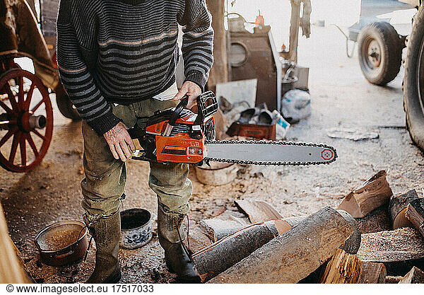 Close-up of a man holding a chainsaw.