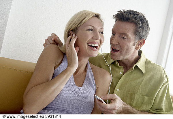 Close-up of a mid adult couple listening to an MP3 player. Close-up of a mid adult couple listening to an MP3 player