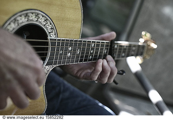 Close up of a pair of hands strumming a guitar