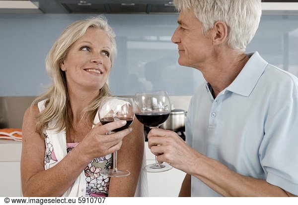 Close-up of a senior couple toasting with glasses of wine and looking at each other