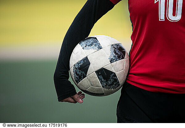 close-up of a soccer ball in the hand of a female soccer player