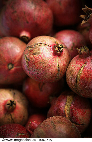 Close up of a stack of pomegranates.