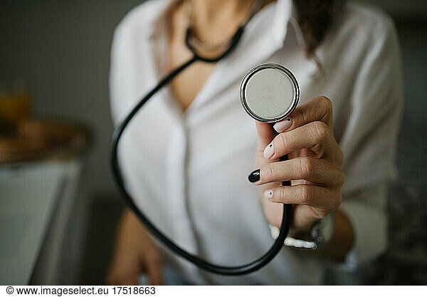 Close-up of a woman holding a stethoscope.