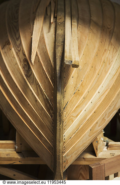 Close up of a wooden boat hull in a boat-builder's workshop.