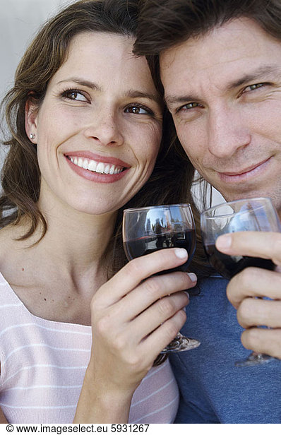 Close-up of a young couple smiling and holding wineglasses. Close-up of a young couple smiling and holding wineglasses