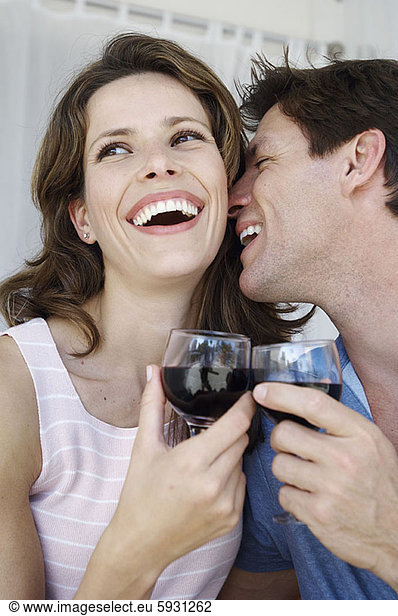 Close-up of a young couple smiling and toasting with wineglasses. Close-up of a young couple smiling and toasting with wineglasses
