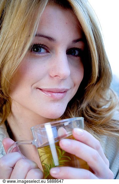 Close_up of a young woman holding a cup of herbal tea