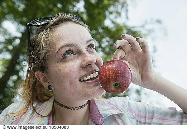 Close-up of a young woman holding red apple  Bavaria  Germany