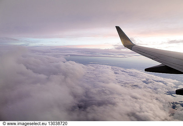 Close-up of aircraft wing flying in cloudy sky