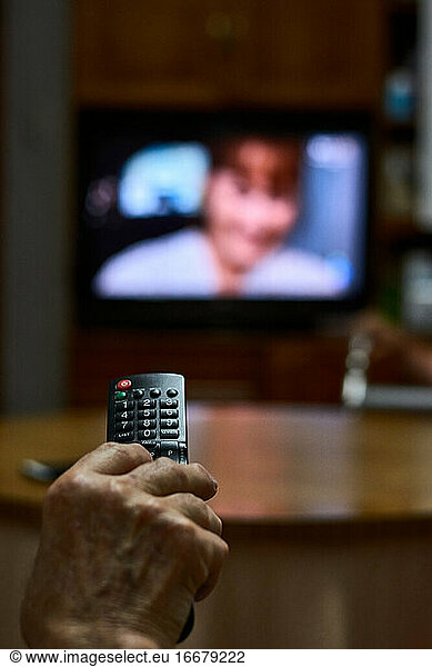 Close-up of an old man changing channels