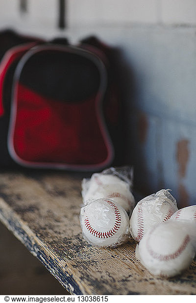 Close-up of baseball balls on wooden table in sports dugout