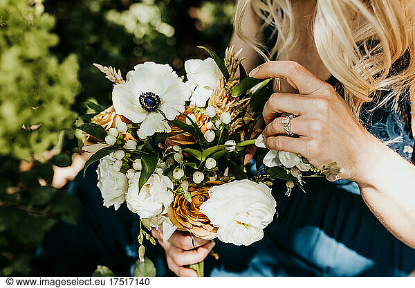 Close up of blonde female holds bouquet of fresh flowers