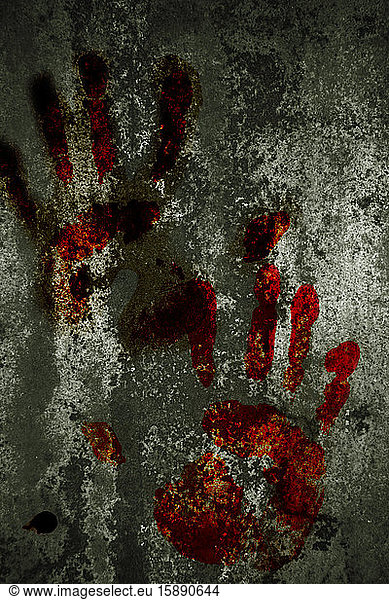 Close-up of bloody handprints on gray weathered wall