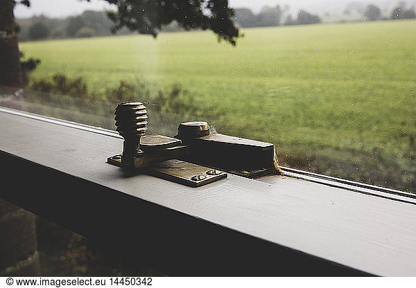 Close up of brass latch on sash window.