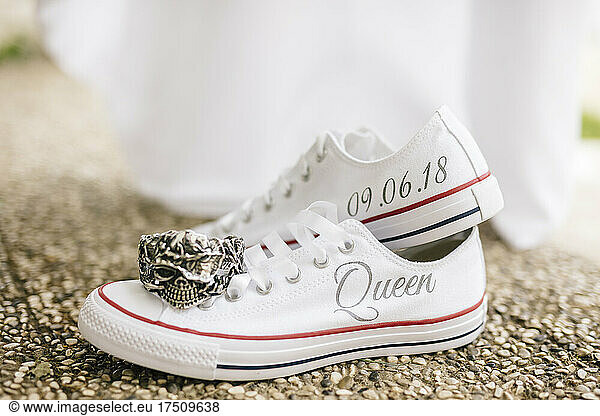 Close-up of bride shoes with text and antique ring on footpath