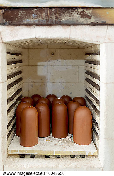 Close-up of brown ceramics in kiln at workshop