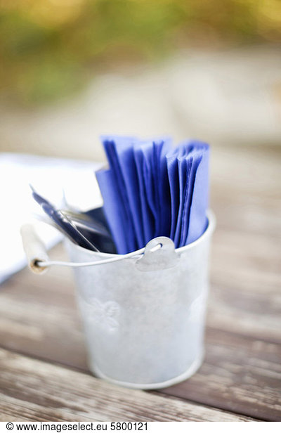 Close-up of bucket filled with blue papers