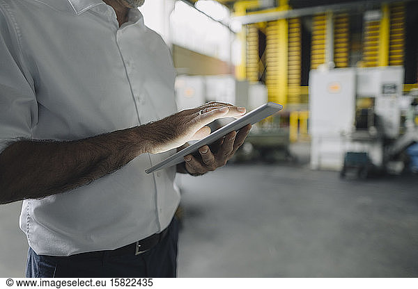 Close-up of businessman using tablet in a factory