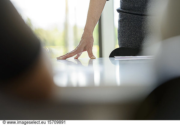 Close-up of businesswoman leaning on desk in office