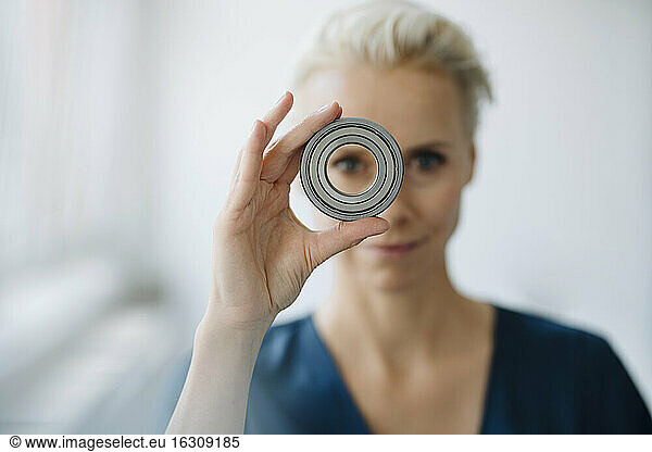 Close-up of businesswoman looking through object in office