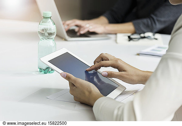 Close-up of businesswoman using tablet during a meeting in office