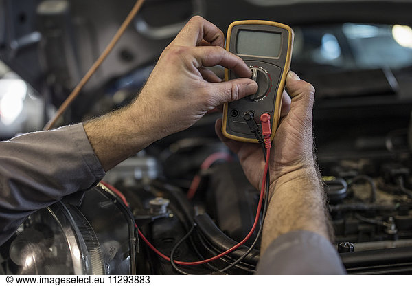 Close-up of car mechanic in a workshop using diagnostic equipment