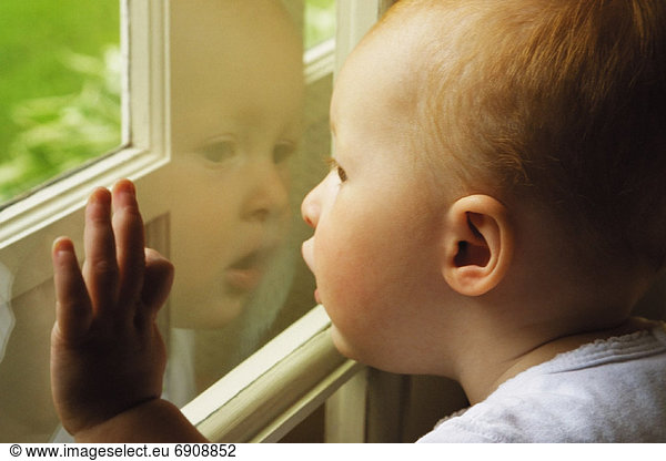 Close-Up of Child Looking Out of Window