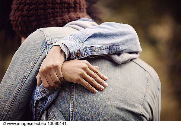 Close-up of couple embracing in filed