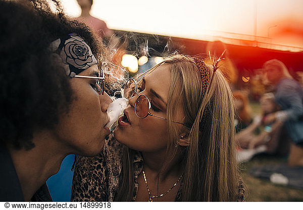 Close-up of couple smoking together at musical event