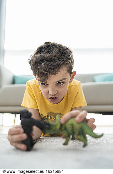 Close-up of cute boy playing with toys on carpet in living room