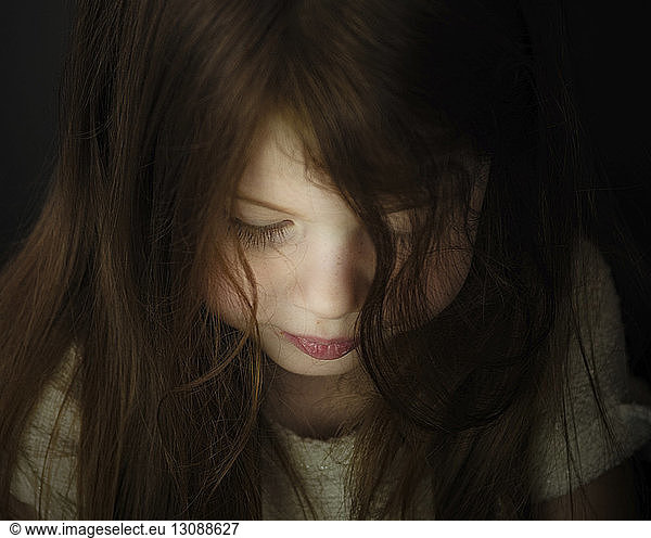 Close-up of cute girl with brown hair in darkroom