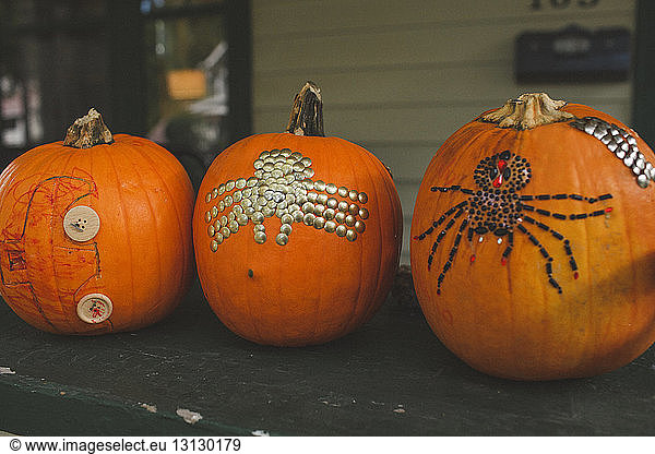 Close-up of decorated pumpkins on wooden table at home during Halloween